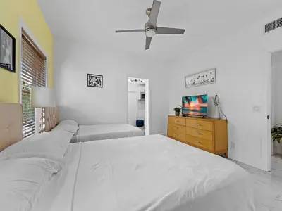 a white bedroom with a bed and a tv at Villa Ciao Bella Sleeps 25 Pool Hot Tub in Miami