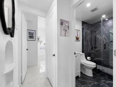 a white bathroom with a toilet and a sink at Villa mi Amor Walkable Pool & Games in Miami