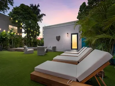 a room with a bed in a yard with grass at Villa mi Amor Walkable Pool & Games in Miami