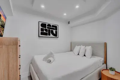 a bedroom with a white bed with white pillows at Bright Beachside 4 Bedrooms 2 Bathrooms Condo Pools Gym and Sauna Access 616 in Miami Beach