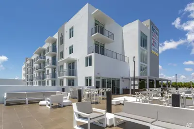 a building with chairs and tables in front of it at Blueground Riverside pool nr Miami River MIA-155 in Miami