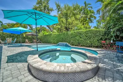a small pool with an umbrella and a patio at Shady Palms - Pool & Jacuzzi in Fort Lauderdale