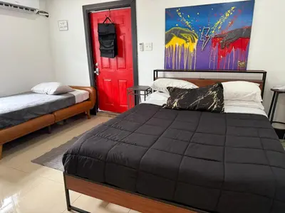 a bedroom with two beds and a red door at Cottage with Hot Tub, Private Firepit, Entrance, Parking BBQ in Miami Gardens