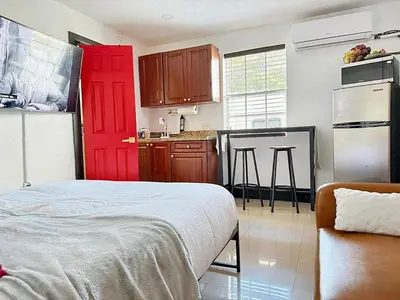 a kitchen with a red door in a room at Cottage with Hot Tub, Private Firepit, Entrance, Parking BBQ in Miami Gardens
