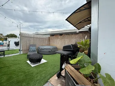 a backyard with green grass and a grill at Cottage with Hot Tub, Private Firepit, Entrance, Parking BBQ in Miami Gardens