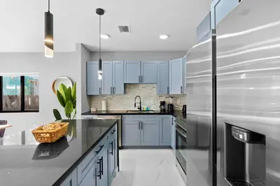 a kitchen with blue cabinets and a stainless steel refrigerator at Comfortable Townhouse - Free Parking Included in Miami