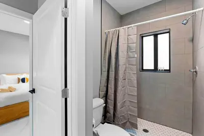 a bathroom with a shower with a toilet and a window at Comfortable Townhouse - Free Parking Included in Miami