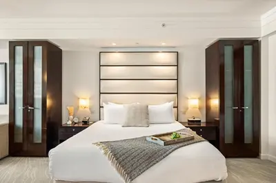 a bedroom with a large white bed and two tables at Stunning Private Studio at Fontainebleau Sorrento - 802 in Miami Beach