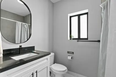 a white bathroom with a sink and a mirror at Stylish Townhouse Steps from Wynwood in Miami