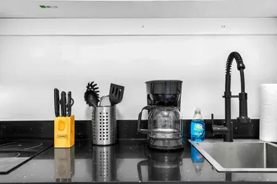 a kitchen counter with a coffee maker and utensils at Modern Studio Near Wynwood & Design District in Miami