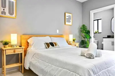 a bedroom with a large white bed with two night stands at Modern Studio Near Wynwood & Design District in Miami