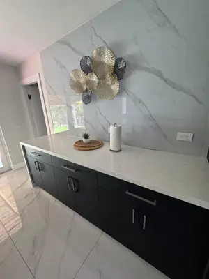 a kitchen with a white marble counter and black cabinets at 12 Guest-In The Center of It All in Miami