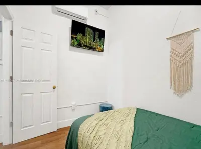 a bedroom with a bed and a tv on the wall at HOT TUB and Washer & Dryer in Unit in Miami