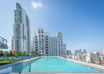 a large swimming pool on the roof of a building with tall buildings at High-Rise Luxury Condo in Downtown Miami with Ocean Views in Miami