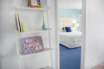 a room with a bed and a book shelf at Seacoast Suites on Miami Beach in Miami Beach