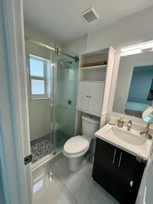 a bathroom with a toilet and a sink and a shower at North Miami Vacation Home in North Miami Beach