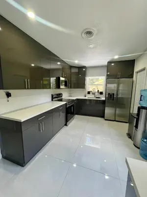 a large kitchen with stainless steel appliances and gray cabinets at North Miami Vacation Home in North Miami Beach