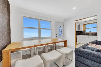 a dining room with a table and chairs and a couch at The Pink Palm Little Havana Pool & Hot Tub in Miami
