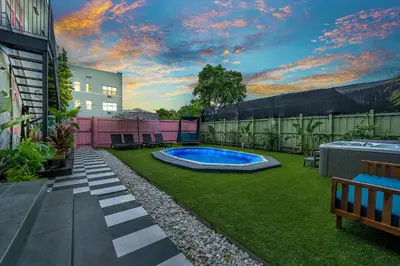 a backyard with a swimming pool and grass at The Pink Palm Little Havana Pool & Hot Tub in Miami