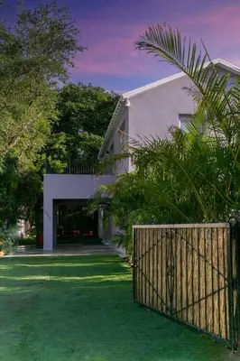 a white house with a gate in front of a yard at The Purple Paradise PoolHot Tub Little Havana in Miami