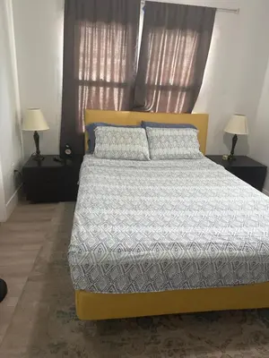 a yellow bed in a bedroom with two lamps at Suite in Dania Beach in Dania Beach