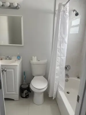 a white bathroom with a toilet and a shower at Suite in Dania Beach in Dania Beach