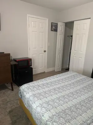 a bedroom with a bed and a desk and two doors at Suite in Dania Beach in Dania Beach