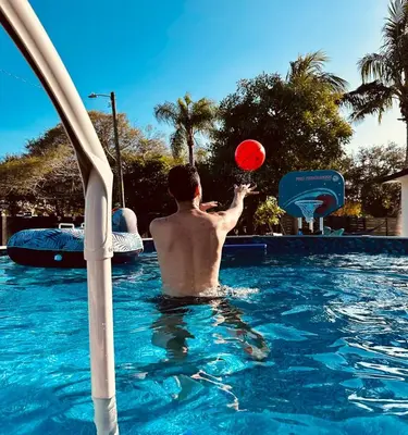 a man playing with a red frisbee in a swimming pool at Villa Las Olas Designed with you in mind! in Fort Lauderdale