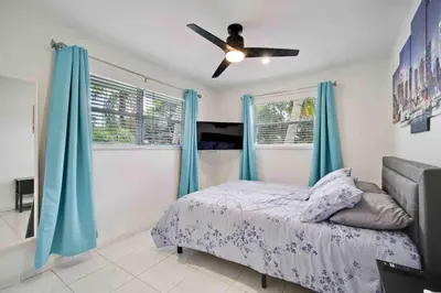 a bedroom with a bed and a ceiling fan at Villa Las Olas Designed with you in mind! in Fort Lauderdale