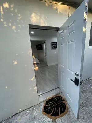 a door leading into a hallway with a door mat at The Vice City Suite - Private stay with Free Parking in the Heart of Miami in Miami