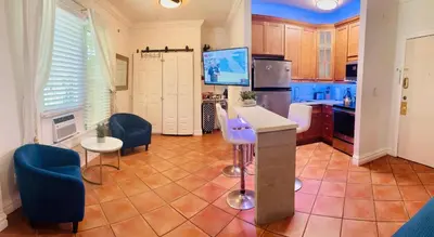 a kitchen with blue chairs and a counter in a room at south beach apartment 5 min walk to the ocean in Miami Beach