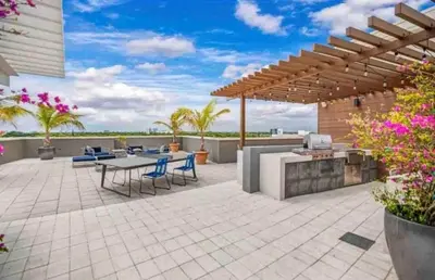 a patio with a table and chairs under a pergola at Midtown Miami Getaway-with pool n parking in Miami