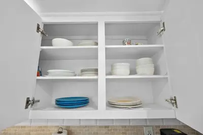 a kitchen cabinet filled with plates and bowls at 1BED Condo w/Pool View | 3rd Floor at Tides in Hollywood