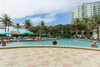 a swimming pool at a resort with people in it at 1BED Condo w/Pool View | 3rd Floor at Tides in Hollywood