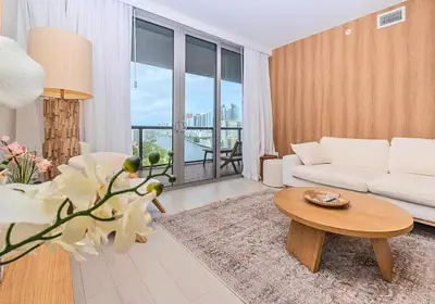 a living room with a white couch and a table at Luxury Ocean View Apartment 1208 Hallandale Beach in Hallandale Beach