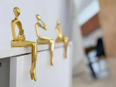 three brass figurines of people sitting on a wall at Newly Renovated 3BR Condo with Bay Views and Parking in Miami