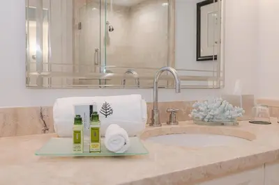 a bathroom with a sink with towels and a mirror at Four Seasons Miami Luxury Two-Bedroom Suite in Brickell - Free Parking in Miami