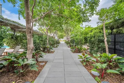 a walkway through a park with trees at Four Seasons Miami Luxury Two-Bedroom Suite in Brickell - Free Parking in Miami