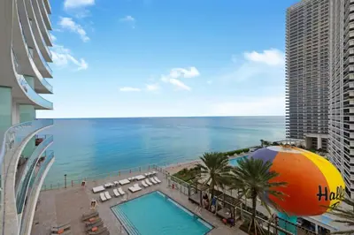 a view of a pool and the ocean from a building at Hollywood Oceanfront Apt in Hollywood