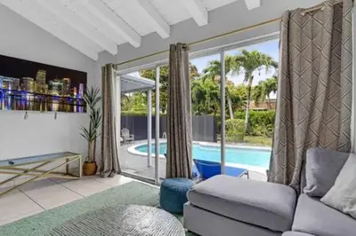 a living room with a couch and a swimming pool at 437 NE 107th · Pool Hot Tub Patio 5 Bedrooms 3 BathsParking in Miami Shores