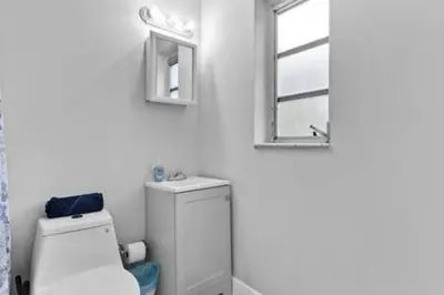 a bathroom with a toilet and a sink and a window at 427 NE 107th Studio · 6BR 3BA 7 Beds Pool Parking 2 Kitchen in Miami Shores