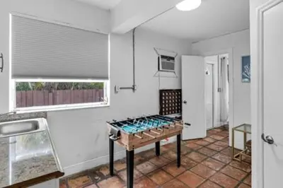a kitchen with a table in the middle of a room at 427 NE 107th Studio · 6BR 3BA 7 Beds Pool Parking 2 Kitchen in Miami Shores