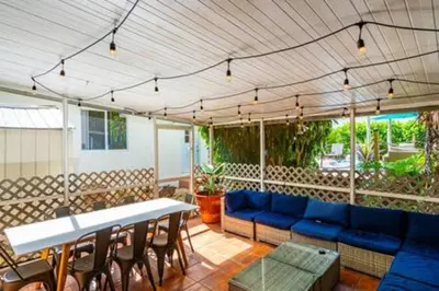a patio with a blue couch and a table and chairs at 427 NE 107th Studio · 6BR 3BA 7 Beds Pool Parking 2 Kitchen in Miami Shores