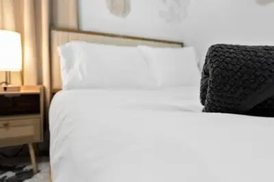 a white bed with a black pillow on top of it at 1834 SW 27th Ave 2 · Vibrant Miami Getaway 2 Beds Near Beach Port in Miami