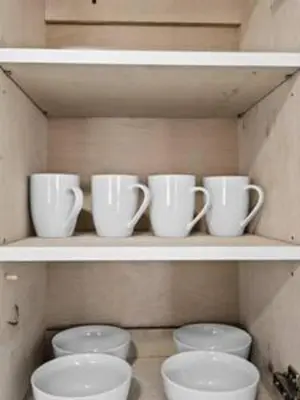 a row of cups and bowls on a shelf at 1834 SW 27th Ave 2 · Vibrant Miami Getaway 2 Beds Near Beach Port in Miami