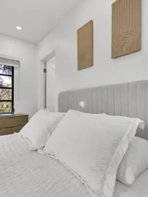 a bedroom with a white bed with two pictures on the wall at 1720 Wa Kee 2A · Luxurious 4BR 3BA Retreat in Coconut Grove w Pool in Miami
