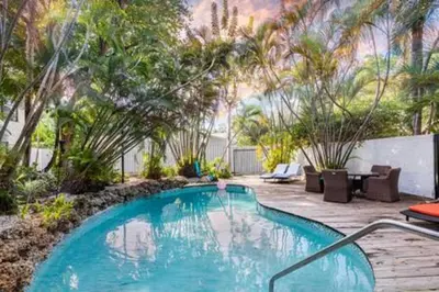 a swimming pool in the middle of a garden at 1720 Wa Kee 1B · 4 Queen Beds Sleep 8 Pool Parking Wi-Fi Patio in Miami