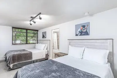 a bedroom with two beds and two windows at 1720 Wa Kee 1B · 4 Queen Beds Sleep 8 Pool Parking Wi-Fi Patio in Miami