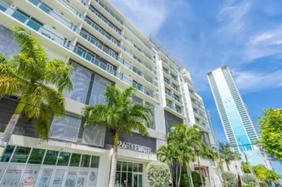 a large building with palm trees in front of it at Modern 1BR Apt In Edgewater Free Parking in Miami