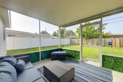 a screened in porch with a couch and a table at 3 Mi to Hard Rock Stadium Retreat with Private Yard in Miramar